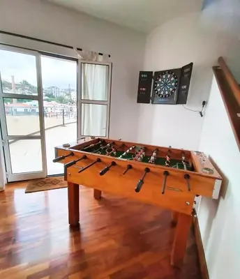 a foosball table in a room with a clock on the wall at A ver o mar rooms- Funchal city center in Funchal