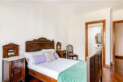 a bedroom with a bed and a table and a mirror at A ver o mar rooms- Funchal city center in Funchal