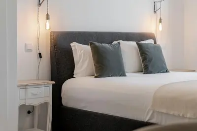 a bedroom with a bed with pillows and a night stand at Uptown 13 apartment by An Island Apart in Funchal
