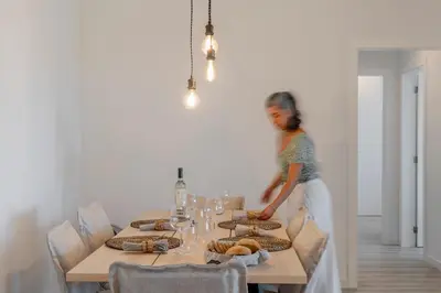 a woman standing next to a table with food on it at Uptown 13 apartment by An Island Apart in Funchal