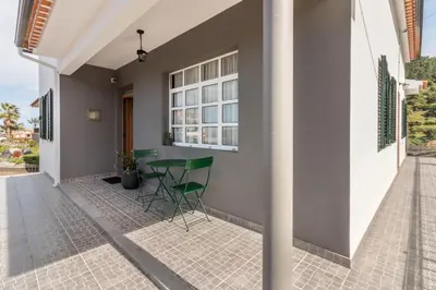 a patio with green chairs and a table on a house at Casa da Olides - T3 and Studio in Santana