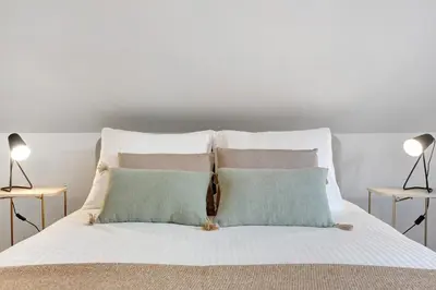 a white bed with two pillows and two lamps at Casa da Olides - T3 and Studio in Santana