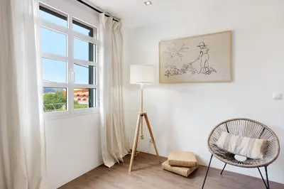 a room with a window and a chair and a lamp at Casa da Olides - T3 and Studio in Santana