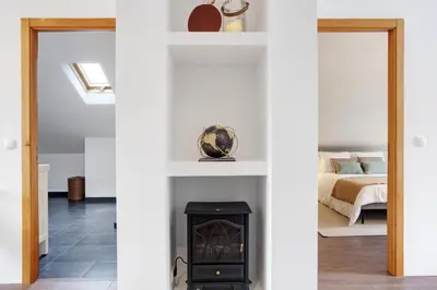 a room with a fireplace and a bedroom with a bed at Casa da Olides - Studio in Santana