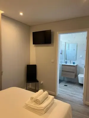 a bedroom with a bed with a television and a bathroom at Ocean Paradise do Til in Funchal