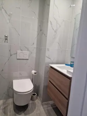 a white bathroom with a toilet and a sink at Ocean Paradise do Til in Funchal