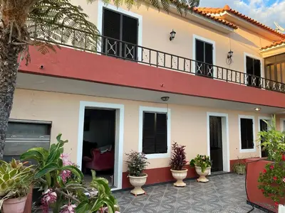 a white and red house with a balcony at Casa da Isilda ,three bedrooms in Estreito da Calheta
