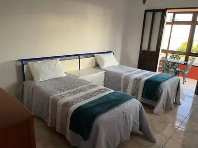 two beds in a room with a window at Casa da Isilda ,three bedrooms in Estreito da Calheta