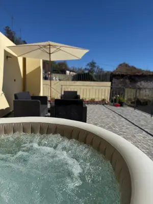two chairs and a table on a balcony with the sunset at Casa do terno com piscina in Arco da Calheta