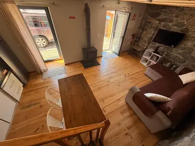 a wooden table and chairs in a living room at Casa do terno com piscina in Arco da Calheta
