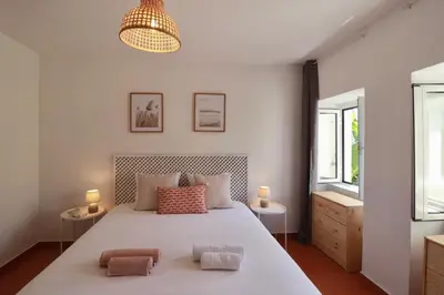 a bedroom with a large white bed with two pillows at Seaside Green House, Paúl do Mar T2 in Paul do Mar