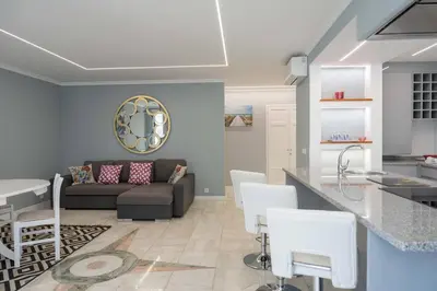 a kitchen and living room with a couch and a table at D.Henrique I apartamento frente ao Savoy Palace in Funchal
