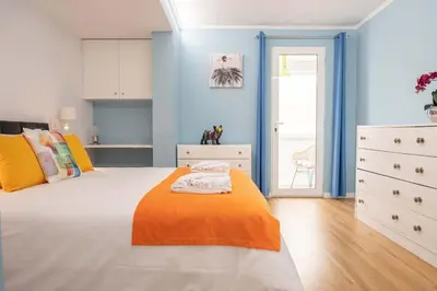 a bedroom with blue walls and a bed with an orange blanket at D.Henrique I apartamento frente ao Savoy Palace in Funchal