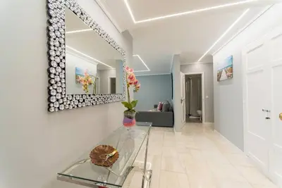a living room with a glass table and a mirror at D.Henrique I apartamento frente ao Savoy Palace in Funchal