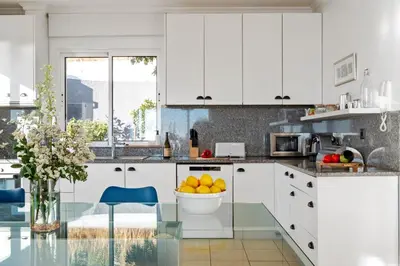 a kitchen with white cabinets and a bowl of fruit at Magnolia Sunsets in Calheta