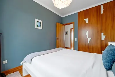 a bedroom with a white bed and blue walls at Magnolia Sunsets in Calheta