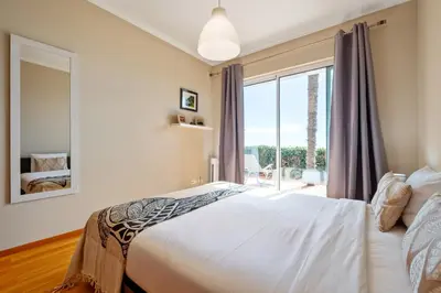 a bedroom with a bed and a large window at Magnolia Sunsets in Calheta