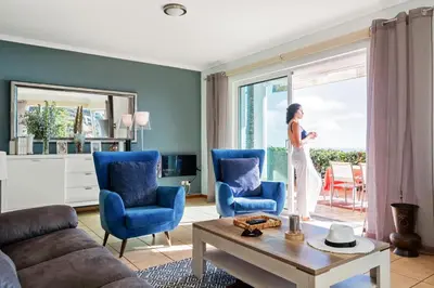 a woman standing in a living room looking out the window at Magnolia Sunsets in Calheta
