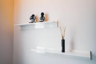 a white shelf with two figurines and a vase on it at Funchal Centrum Apartment in Funchal