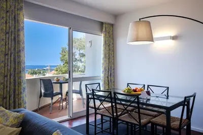 a living room with a table with chairs and a dining room at GuestReady - Serenity by the Sea near Funchal Bay in Funchal