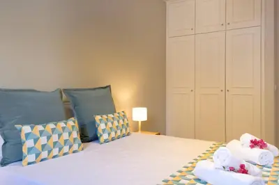 a bedroom with a large bed with blue pillows at GuestReady - Serenity by the Sea near Funchal Bay in Funchal