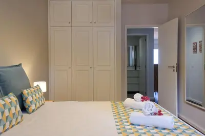a room with a bed with a chair and a closet at GuestReady - Serenity by the Sea near Funchal Bay in Funchal