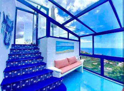 a living room with a couch and a large window at Casa Santorini in Ribeira Brava