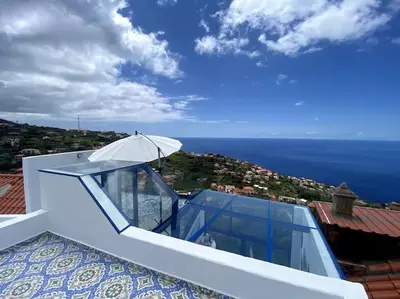 a house with a balcony with a view of the ocean at Casa Santorini in Ribeira Brava