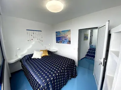 a bedroom with a bed with a blue floor at Casa Santorini in Ribeira Brava