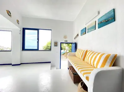 a living room with a yellow and white couch at Casa Santorini in Ribeira Brava