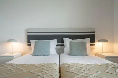 a bedroom with two beds with pillows and two lamps at Apartamento Princesa Dona Amélia by An Island Apart in Funchal