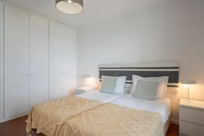 a white bedroom with a bed with two pillows at Apartamento Princesa Dona Amélia by An Island Apart in Funchal