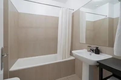 a bathroom with a sink and a bath tub and a mirror at Apartamento Princesa Dona Amélia by An Island Apart in Funchal