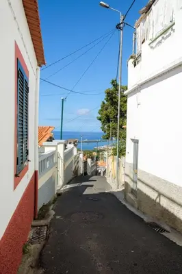 an alley way between two white buildings and a street at GuestReady - An amazing blue ocean view in Funchal