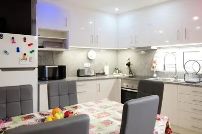 a kitchen with white cabinets and a table with fruits on it at GuestReady - An amazing blue ocean view in Funchal