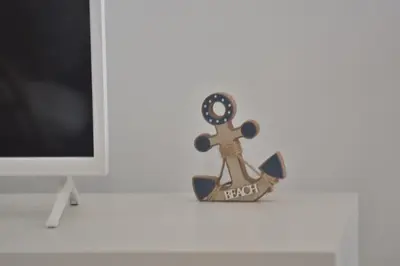 a toy ship on a desk next to a computer monitor at Abrigo das Matas in Porto Santo