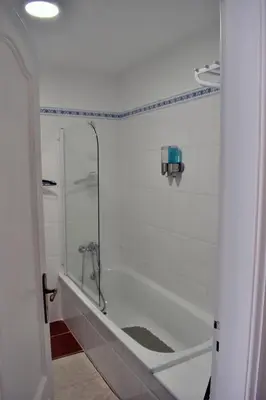 a white bathroom with a shower and a tub at Abrigo das Matas in Porto Santo