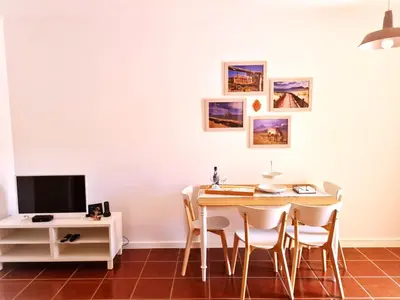 a dining room with a table and chairs and a tv at Abrigo das Matas in Porto Santo