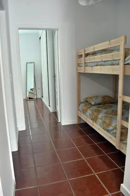 a room with two bunk beds and a tiled floor at Abrigo das Matas in Porto Santo