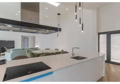 a kitchen with white cabinets and a white counter top at The pool house in Ponta de Sol in Funchal