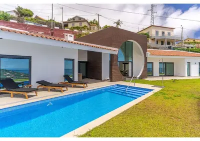 a bedroom with a large bed with a large window at The pool house in Ponta de Sol in Funchal