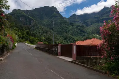 a road with a fence and mountains in the background at Casa do Rosário by An Island Apart in São Vicente
