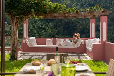 a woman sitting on a couch under a pergola at Casa do Rosário by An Island Apart in São Vicente