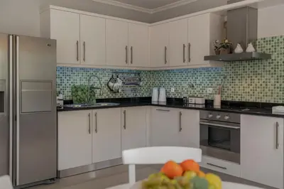 a kitchen with white cabinets and a plate of fruit at Casa do Rosário by An Island Apart in São Vicente