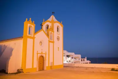 a yellow and white church with a clock tower at B69 - Village of Luz Apartment in Luz