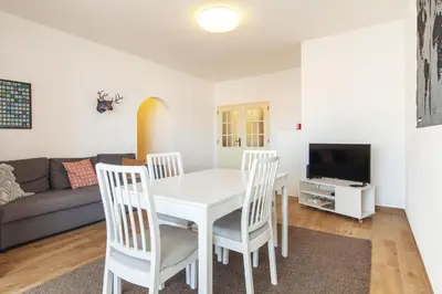 a living room with a table and chairs and a couch at B69 - Village of Luz Apartment in Luz