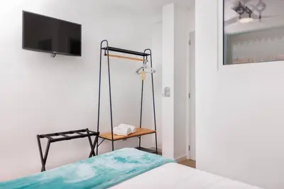 a bedroom with blue shutters and a bed and two chairs at Villa Belafonte in Câmara de Lobos