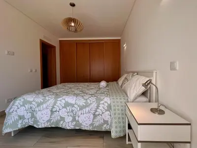 a bedroom with a bed and a lamp and a table at Villa Sonata in Ingrina Sol in Raposeira