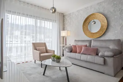 a living room with a couch and a chair and a mirror at Fifth Apartment by Homie in Funchal