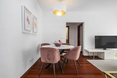 a dining room with a table and chairs and a tv at Fifth Apartment by Homie in Funchal